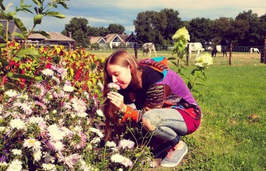 woman-bent-down-sniffing-flower